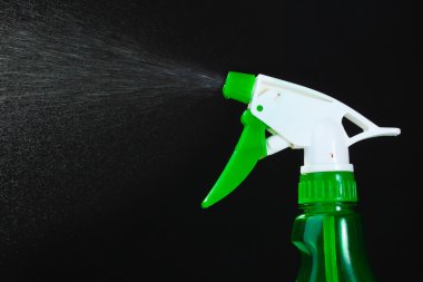 Spray bottle and spraying on black background clipart