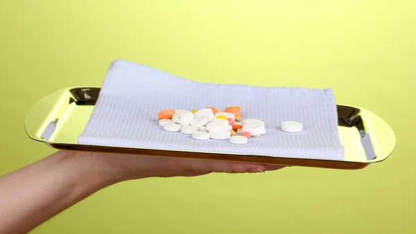 Tablett mit Tabletten auf grünem Hintergrund — Stockfoto
