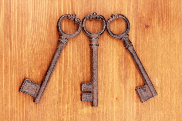 Trzy zabytkowe klucze na drewniane tła — Zdjęcie stockowe