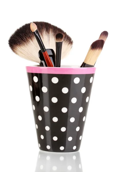 Cepillos de maquillaje en una taza de lunares negro aislado en blanco — Foto de Stock