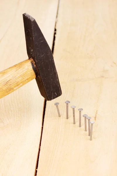 Pregos de metal em prancha de madeira e martelo — Fotografia de Stock