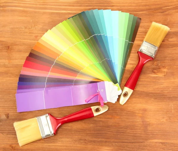 Ecsetek és világos paletta színek, fából készült háttér — Stock Fotó