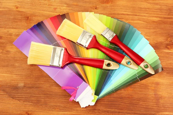 Verf penselen en helder palet van kleuren op houten achtergrond — Stockfoto