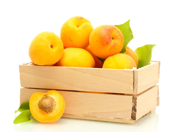 Rijp abrikozen met groene bladeren in houten doos geïsoleerd op wit — Stockfoto