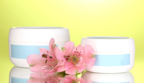 Pots de crème avec fleur sur fond vert — Photo