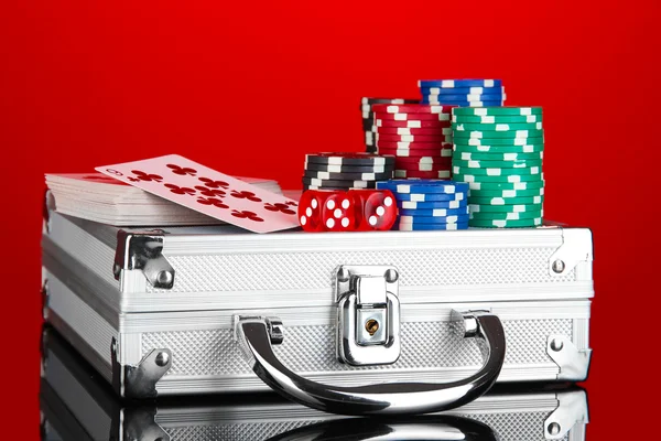 Poker parlak kırmızı zemin üzerine metalik bir davada ayarla — Stok fotoğraf
