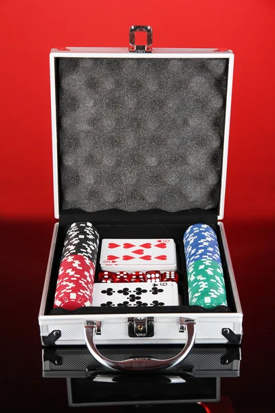 Poker impostato in caso metallico su sfondo rosso brillante — Foto Stock