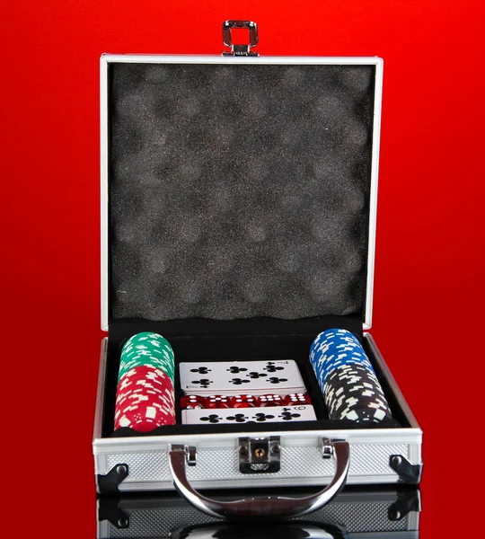 Poker impostato in caso metallico su sfondo rosso brillante — Foto Stock