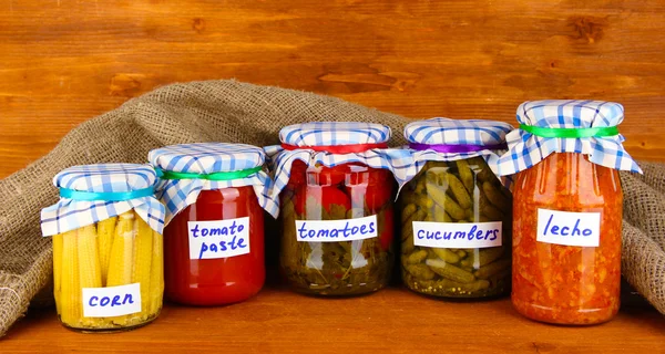 Jars with canned vegetables on green background close-up — Stock Photo, Image