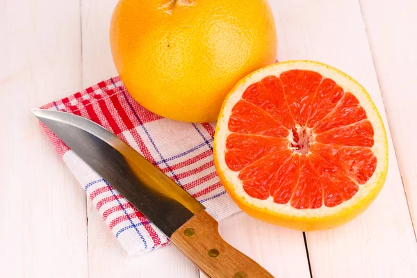 Mogen grapefrukt och hälften på servett på trä bakgrund — Stockfoto