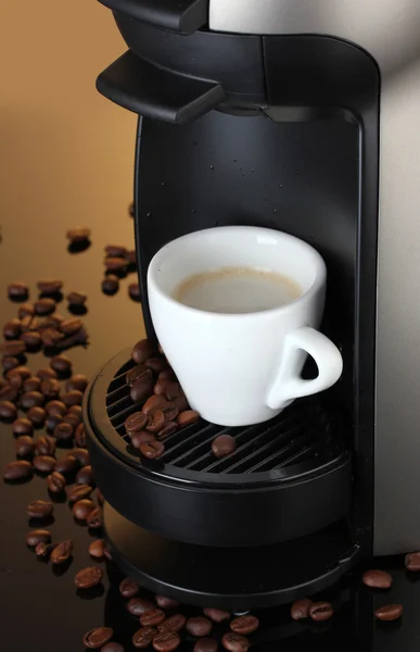 Еспресо машини і чашка кави на коричневому фоні — стокове фото