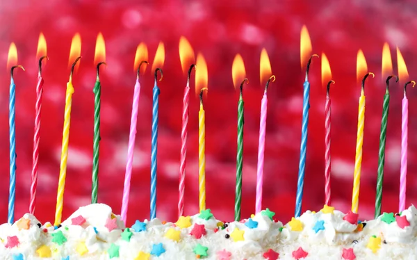 Mooie birthday kaarsen op rode achtergrond — Stockfoto