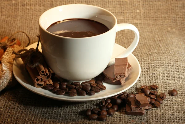 Taza de café, frijoles y chocolate en el fondo de saqueo — Foto de Stock