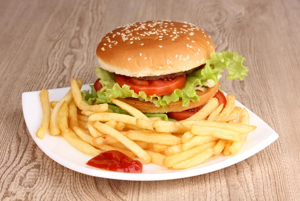 Duże i smaczne hamburgerów i smażonymi ziemniakami na tabliczce na drewnianym stole — Zdjęcie stockowe