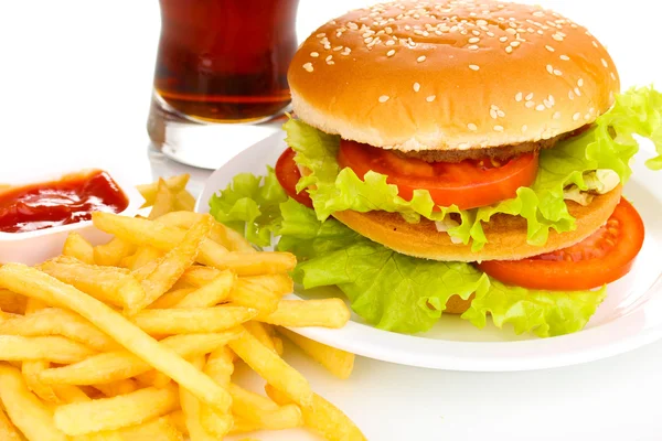 Hamburger grande e gustoso su piatto con cola e patate fritte primo piano — Foto Stock