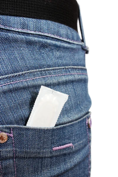 Preservativo no bolso de calças de ganga azuis em branco — Fotografia de Stock
