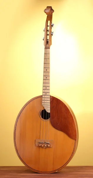 Retro kobza- Ukrainian musical instrument on wooden table on yellow background — Stock Photo, Image