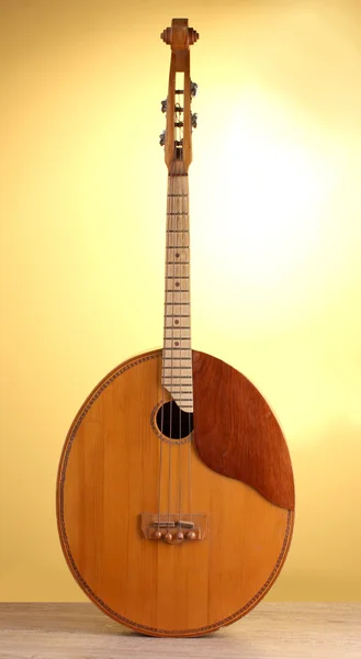 Ретро-кобза - украинский музыкальный инструмент на деревянном столе на желтом фоне — стоковое фото