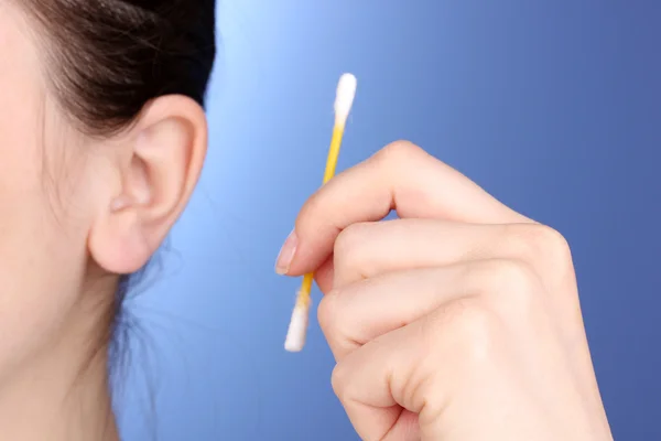 Human ear and cotton swabs close-up on blue background — Stock Photo, Image