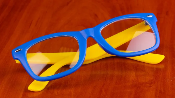 木製の背景に美しい色のメガネ — ストック写真