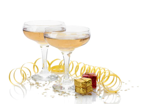 Verres de champagne, cadeaux et serpentine isolés sur un blanc — Photo