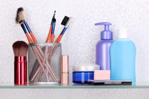 Shelf with cosmetics and toiletries in bathroom — Stock Photo, Image