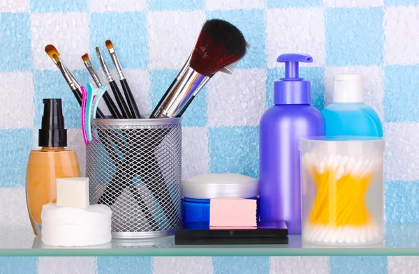 带有化妆品和化妆用具在浴室的架子上 — 图库照片