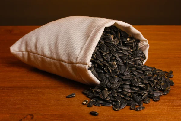 Sacchetto di panno di semi di girasole su tavolo di legno su sfondo marrone — Foto Stock