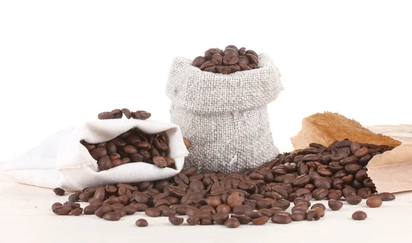 Leinensack mit Kaffeebohnen und Papiertüte mit Kaffee isoliert auf weiß — Stockfoto