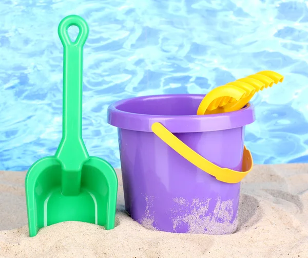 stock image Children's beach toys on sand on water background