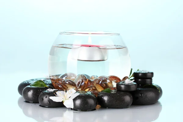 Komposition der Vase mit Kerze und Wellness-Steinen auf blauem Hintergrund — Stockfoto