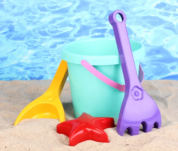 Çocukların plaj oyuncakları kum su arka plan üzerinde — Stok fotoğraf