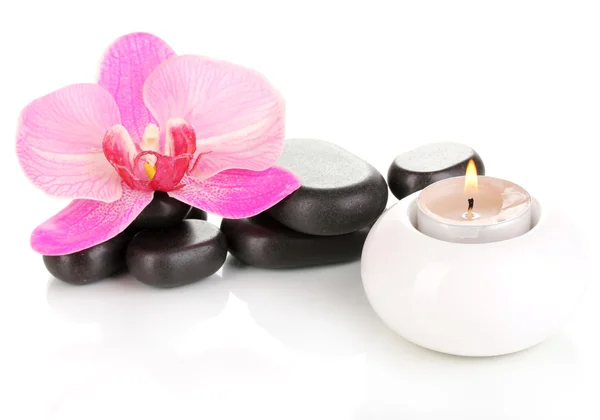 Курортные камни с цветком орхидеи и свечи изолированы на белом — стоковое фото