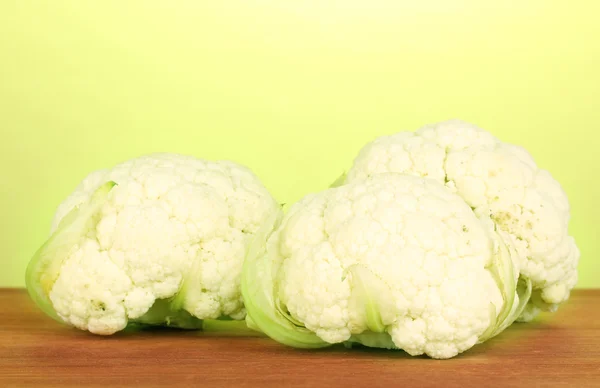 Fresh cauliflower on wooden table on green background — Stock Photo, Image