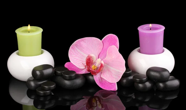 Спа камені з орхідеєю та свічками ізольовані на чорному — стокове фото