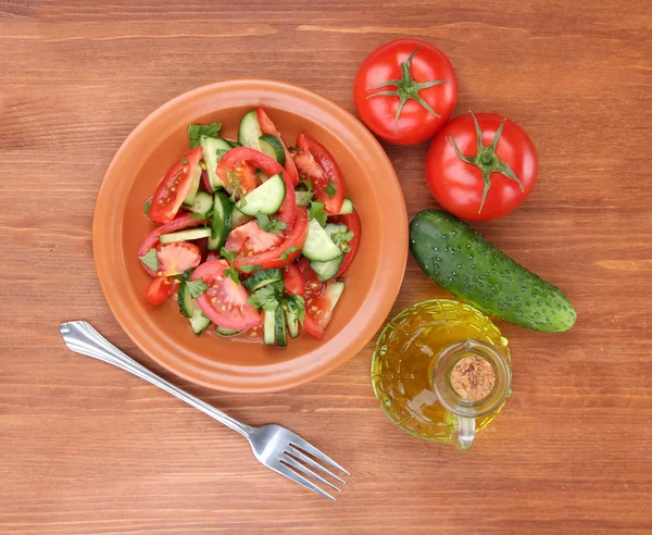 Salada fresca com tomates e pepinos em fundo de madeira — Fotografia de Stock