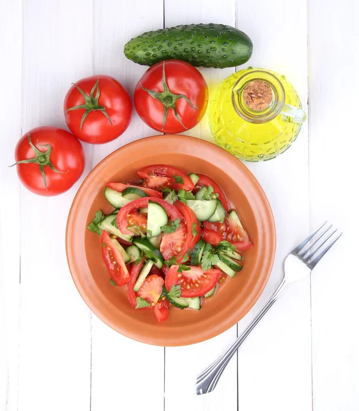 Ensalada fresca con tomates y pepinos sobre fondo de madera blanca — Foto de Stock