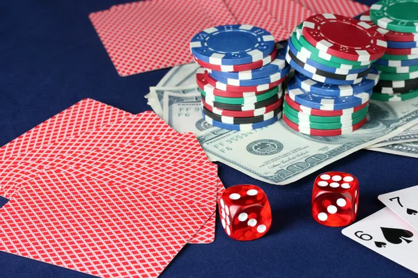 Голубой покерный стол с сигарами, фишками для покера, игральными картами и долларами крупным планом — стоковое фото