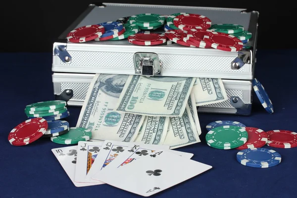 Koffer mit Dollars auf dem blauen Pokertisch — Stockfoto
