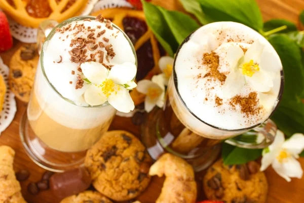 Окуляри кавового коктейлю на дерев'яному столі з солодкими квітами — стокове фото