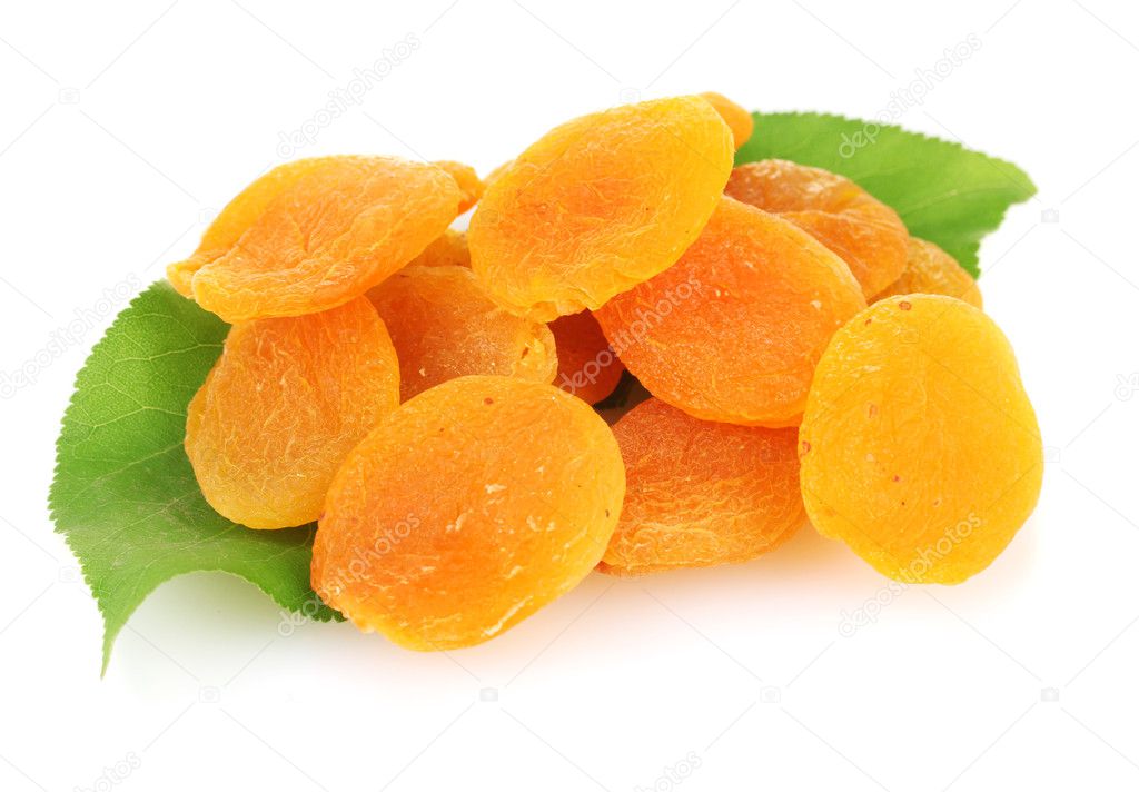 Delicious dried apricots on green leaves isolated on white
