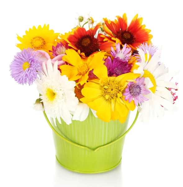 Beautiful bouquet of bright wildflowers in green metal bucket, on wooden table on blue background — Stock Photo, Image