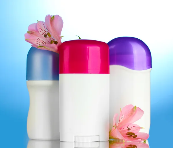 Mavi zemin üzerine çiçekli deodorantlar — Stok fotoğraf