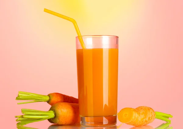 Vidro de suco de cenoura no fundo rosa-amarelo — Fotografia de Stock