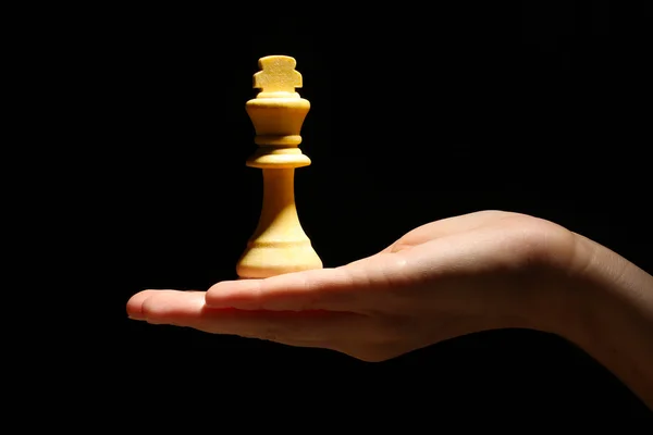 Peça de xadrez na mão isolada em preto — Fotografia de Stock