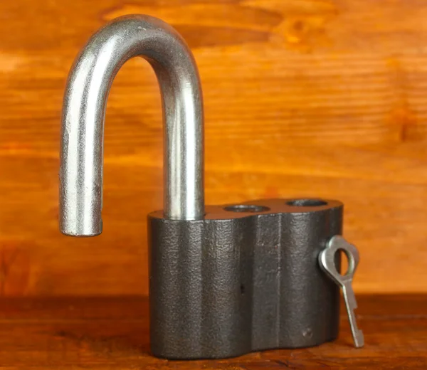 Cadeado velho com chave no fundo de madeira close-up — Fotografia de Stock