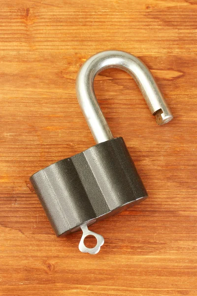 Old padlock with key on wooden background close-up — Stock Photo, Image