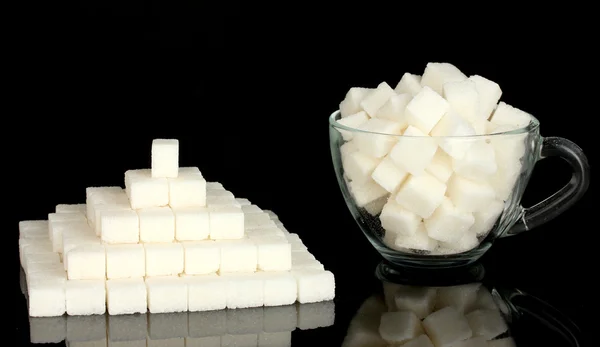 Raffinierter Zucker im Glasbecher isoliert auf schwarz — Stockfoto