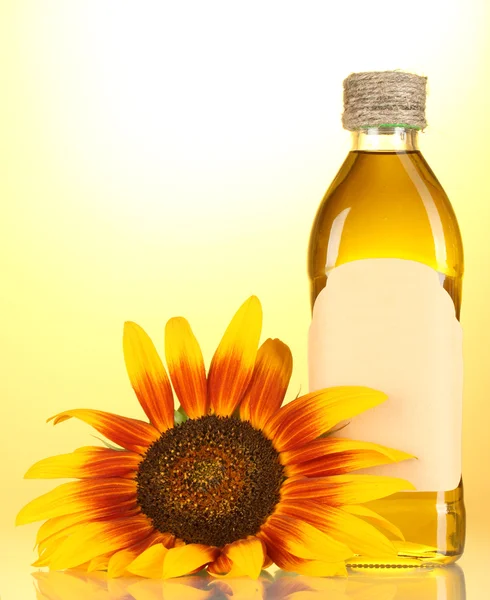 Olej słonecznikowy i słonecznik na żółtym tle — Zdjęcie stockowe