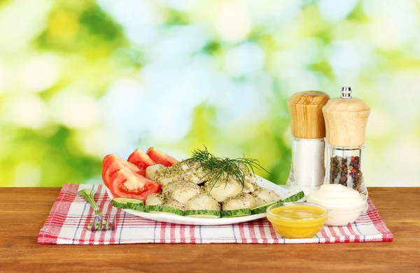 Leckere gekochte Knödel mit Gemüse im Gericht auf hellgrünem Hintergrund — Stockfoto